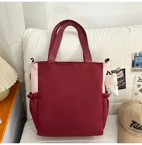 Stylish two-tone canvas tote bag with top handles and adjustable shoulder strap, large capacity.