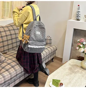 Grey corduroy backpack with cute bear pendant and white lace trim, casual school bag design.