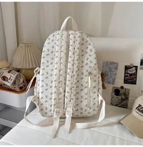 Corduroy backpack detail view, showing adjustable straps and cute bow print pattern style.