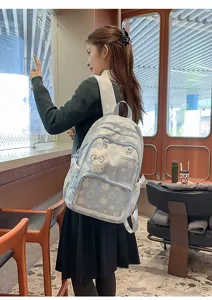 Detail view of Japanese style blue star print school backpack with multi compartments and plush charm.
