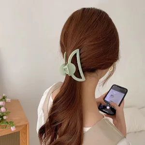 Matte green crescent hair claw clip for women, large hollow hair accessory for styling.