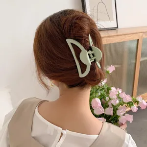 Detailed shot of a green hair claw clip showcasing its matte texture and geometric cutout design.
