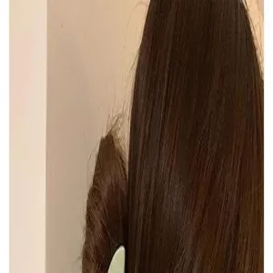 Close-up detail shot of a large matte hair claw clip in a stylish coffee color worn on hair.