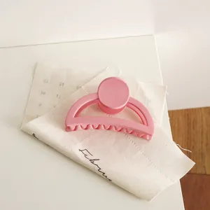Pink matte half-round hair claw clip for women, stylish minimalist daily hair styling accessory.