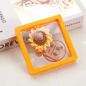 Handmade crochet sunflower keychain with blessing charm and transparent display box packaging.