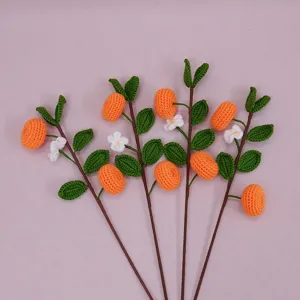 Handmade crochet kumquat flower bouquet, knitted orange branches with green leaves for home festive decor detail view.