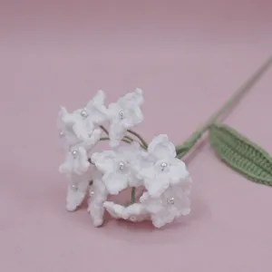 Handmade crochet white hydrangea flower with pearl center, detailed botanical craft for decor.
