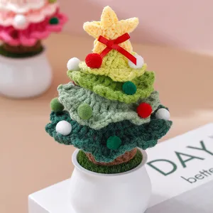 Gros plan de sapin de Noël au crochet fait main, jolie plante en pot tricotée colorée.