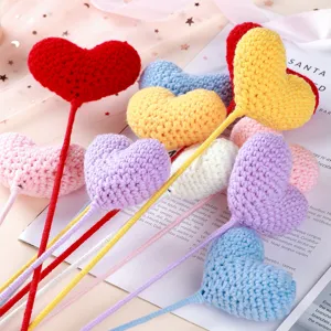Closeup details of handmade crochet heart flower bouquet, colorful yarn art decor.