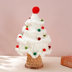 Close-up detail of handmade knitted Christmas tree decor, textured yarn balls and wooden base.