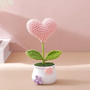 Handmade crochet pink heart flower potted plant, creative home decor detail display.