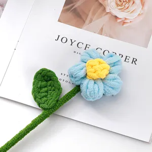 Close-up detail of handmade crochet blue puff flower with green stem, cute wool bouquet gift.