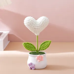 Close-up of handmade crochet heart flower in mini pot, cute desk decor, cozy aesthetic detail.
