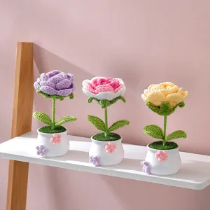 Détail de pot de fleurs roses au crochet, jolie décoration florale tricotée pour la maison.