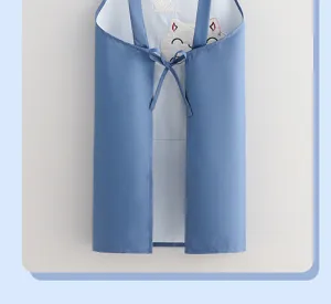 Detailansicht einer blauen wasserdichten Schürze mit süßer Katzenstickerei und Rückengurten.