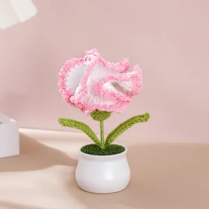 Close-up view of handmade crochet potted carnation plant with lovely pink flowers.
