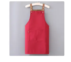 Grembiule da lavoro in tela rossa con bretelle marroni e tasca frontale per cucina.