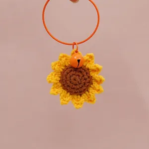 Handmade crochet sunflower charm detail shot, featuring vibrant yellow petals and brown center.