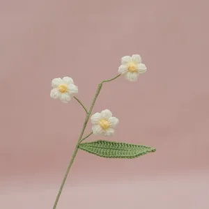 Handmade crochet puff flower branch detail, delicate white petals and green leaves for home decor.
