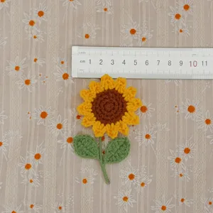 Handmade crochet sunflower brooch detail view, knit flower accessory showing actual size.