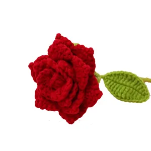 Nahaufnahme Detail der handgefertigten Häkel-rote Rose mit grünem Blatt und schöner Stricktextur.