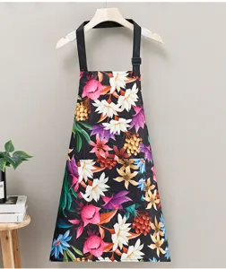 Detailed view of the waterproof floral kitchen apron, featuring adjustable straps and front pocket.
