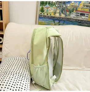 Detail view of light green sports backpack showing breathable mesh shoulder straps and side pocket.