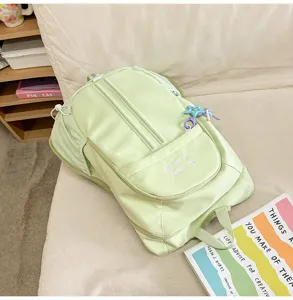 Detail view of a light green casual backpack, large capacity outdoor sports travel bag.