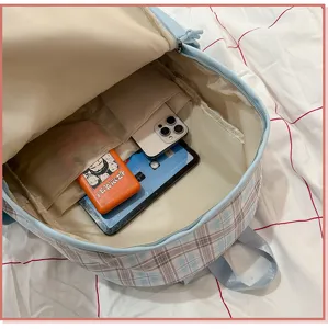 Vista interior de mochila escolar a cuadros azules con amplios compartimentos.