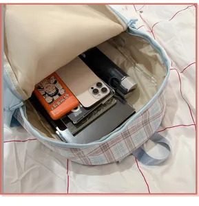 Vista detallada del interior espacioso de la mochila escolar a cuadros azul claro para estudiantes.