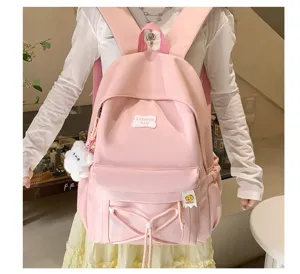 Pink student backpack detail featuring sweet candy color, front badge, and cute bear charm.