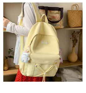 Canvas student school bag in candy yellow with cute bear pendant and spacious front pocket.