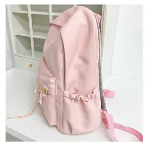 Detail view of the pink canvas student backpack featuring side pockets and front zip compartment.