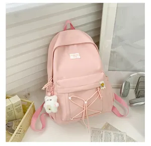 Cute pink student backpack with bear pendant, sweet Japanese style school bag for daily use.