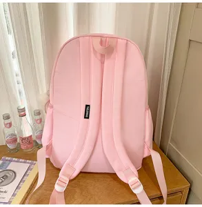 Detail shot of cute pink school backpack on wooden desk with nice aesthetic background.
