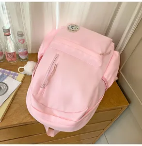 Pink Korean style student backpack minimalist casual school bag with front zipper pocket detail.