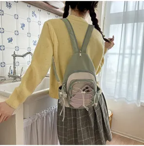 Casual minimalist dual-use backpack sling bag in soft sage green and white color block style.