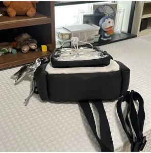 Transparent pocket mini backpack detail, black and white color block design, front view.