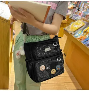 Detailed view of the black canvas transparent ita bag with multi-pockets and cute badges.