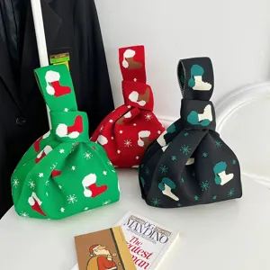 Primo piano sul dettaglio della borsa in maglia natalizia con motivo a calza e colori vivaci.