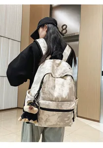 Detailed view of large capacity vintage tie-dye backpack with cute dog plush pendant.
