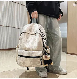 Vintage tie-dye canvas backpack with cute plush pendant, casual large capacity school bag.