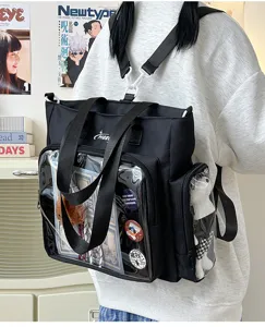 Detail view of black canvas itabag with clear front pocket for anime pins and school use.