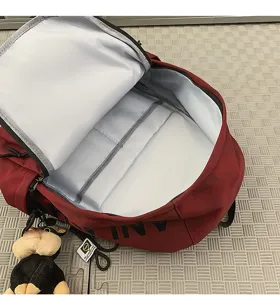 Detailed view of the vintage large capacity red backpack interior and attached cute monkey toy.