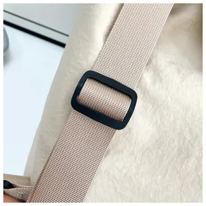 Close-up detail of casual backpack adjustable strap and durable black plastic buckle.