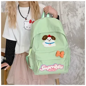 Light green canvas backpack detail showcasing cute dog embroidery patch, bow decor and text.