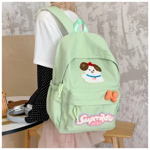 Detailed lifestyle view of the cute candy-colored canvas backpack featuring dog embroidery.