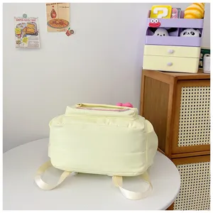 Detail shot of the cute light yellow casual backpack bottom and back design in room corner.