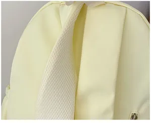 Close-up detail of light yellow backpack with breathable mesh shoulder straps, simple design.