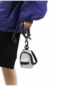Vista detallada del mini monedero de mochila plateado con cordón y gancho resistente.